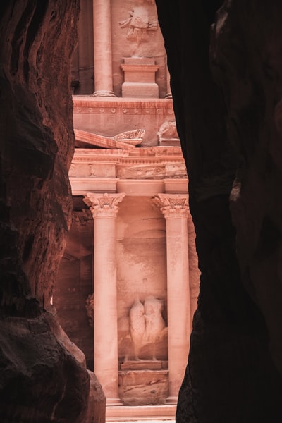 man in black jacket standing on brown rock formation during daytime